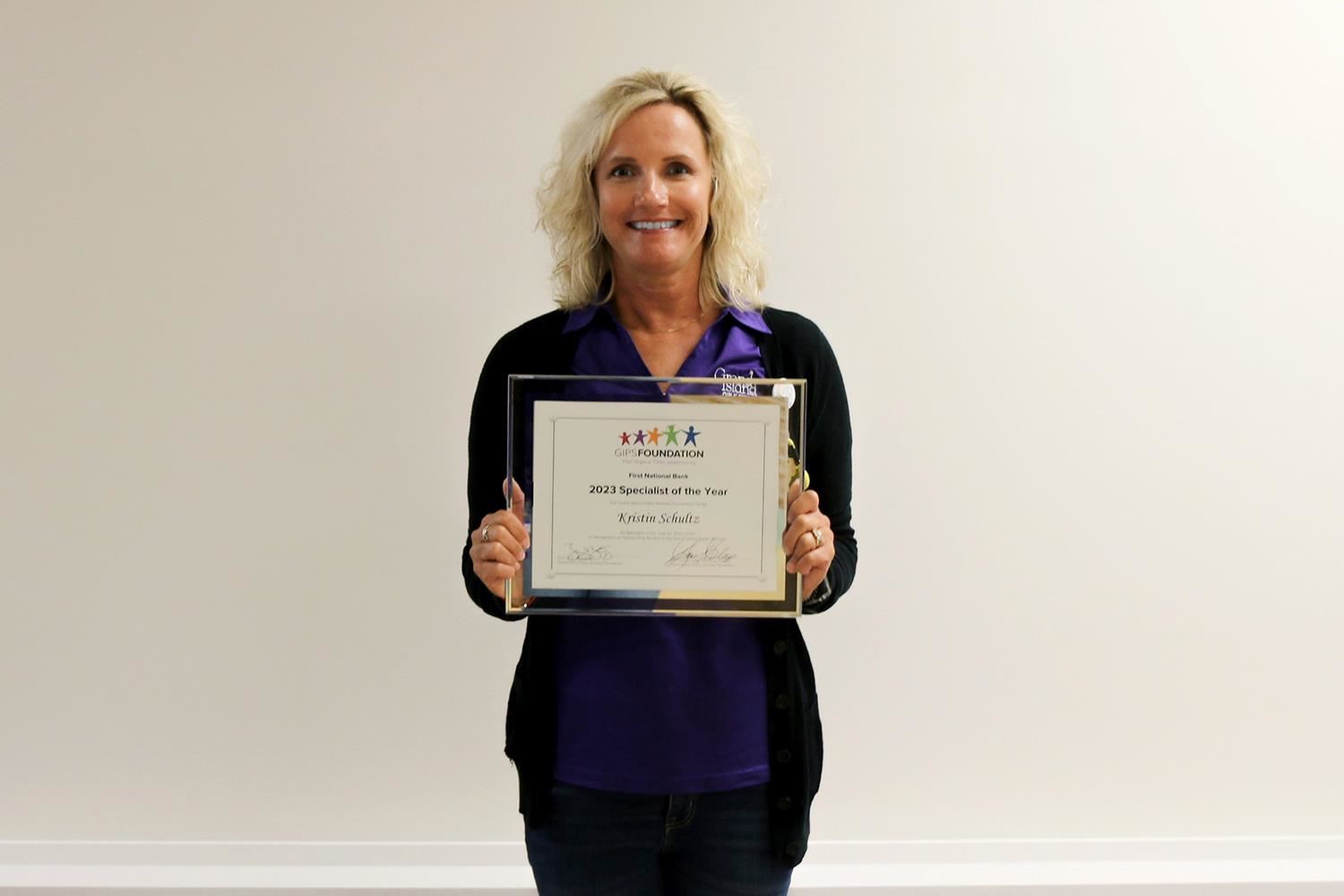 Kristin Schultz smiling with her Specialist of the Year plaque